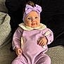 baby, child, smiling, headband, bow, purple_outfit, sitting, couch, cushion, cozy, indoor, portrait, cute, happy, infant, clothing, hands, face, blue_eyes, soft_lighting