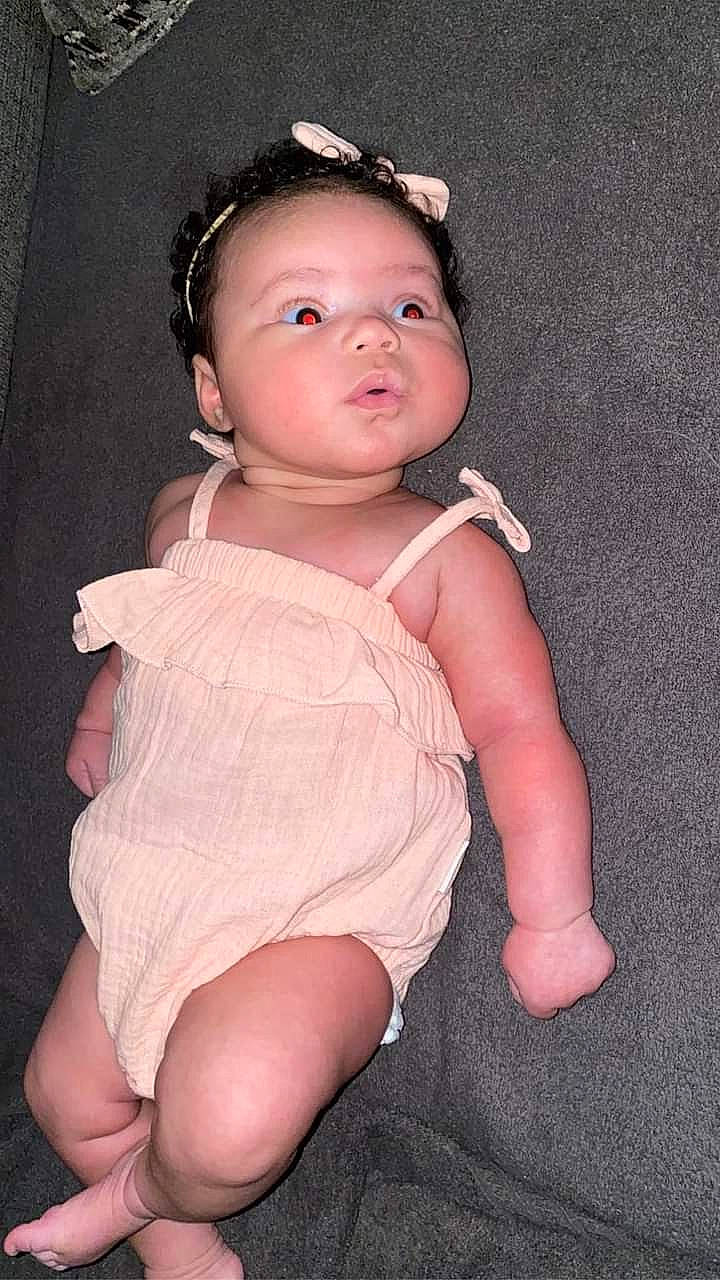 Samaya is registered to the contest to win money with this photo: baby, baby_toddler_clothing, cheek, dress, eye, eyelash, face, finger, flash_photography, hair, hand, head, human_leg, lip, nail, person, pink, sleeve, thigh, thumb