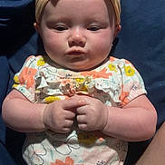 Sophia joined the competition — help win amazing prizes! baby, child, headband, bow, floral_clothing, onesie, shorts, hands, fingers, face, cheeks, sitting, infant, cute, skin, person, expression, indoors, fabric, background
