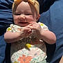 baby, child, smiling, headband, bow, shirt, floral_pattern, shorts, clapping, hands, lying_down, blanket, blue, happy, cute, infant, person, indoors, soft_light, sleepwear