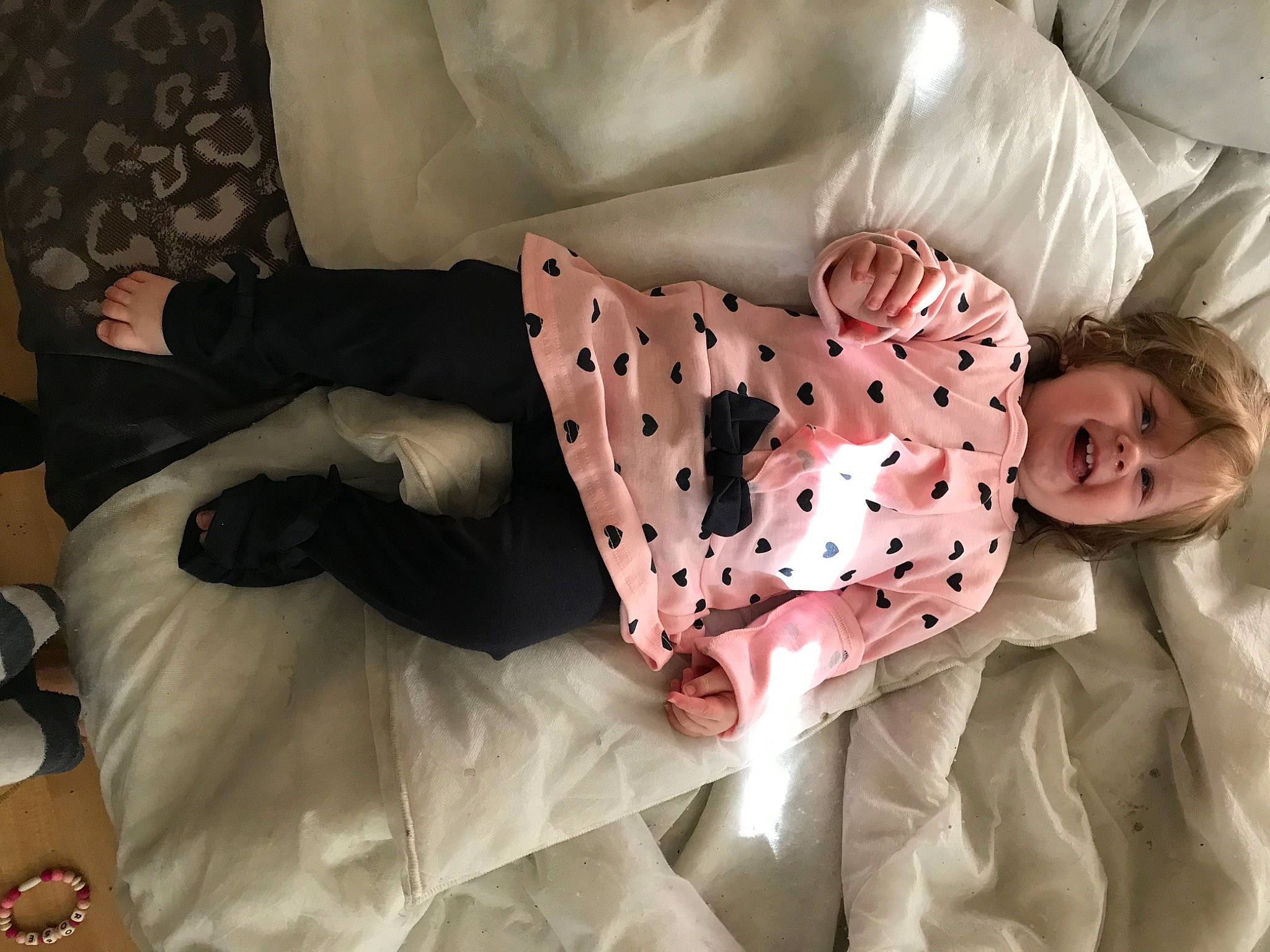 Rose a rejoint le concours — aidez-le/la à gagner de superbes lots ! baby, baby_products, baby_toddler_clothing, bed_sheet, bedding, child, comfort, couch, flesh, human_leg, knee, linens, magenta, pattern, person, room, sitting, sleeve, smile, thigh