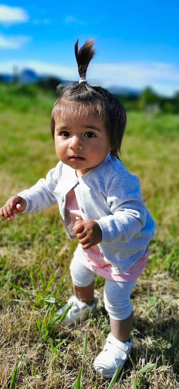 Leïna participe au concours pour gagner de l'argent avec cette photo : baby_toddler_clothing, eye, flash_photography, fun, gesture, grass, grass_family, grassland, hair, happy, head, iris, leisure, meadow, people_in_nature, person, prairie, skin, sky, sunlight