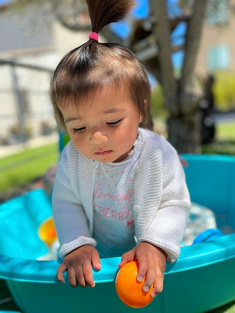 Leïna a rejoint le concours — aidez-le/la à gagner de superbes lots ! arm, baby, baby_playing_with_toys, baby_products, baby_toddler_clothing, child, fashion_accessory, fun, grass, hand, happy, leisure, person, photograph, play, playground, recreation, sitting, summer, toddler