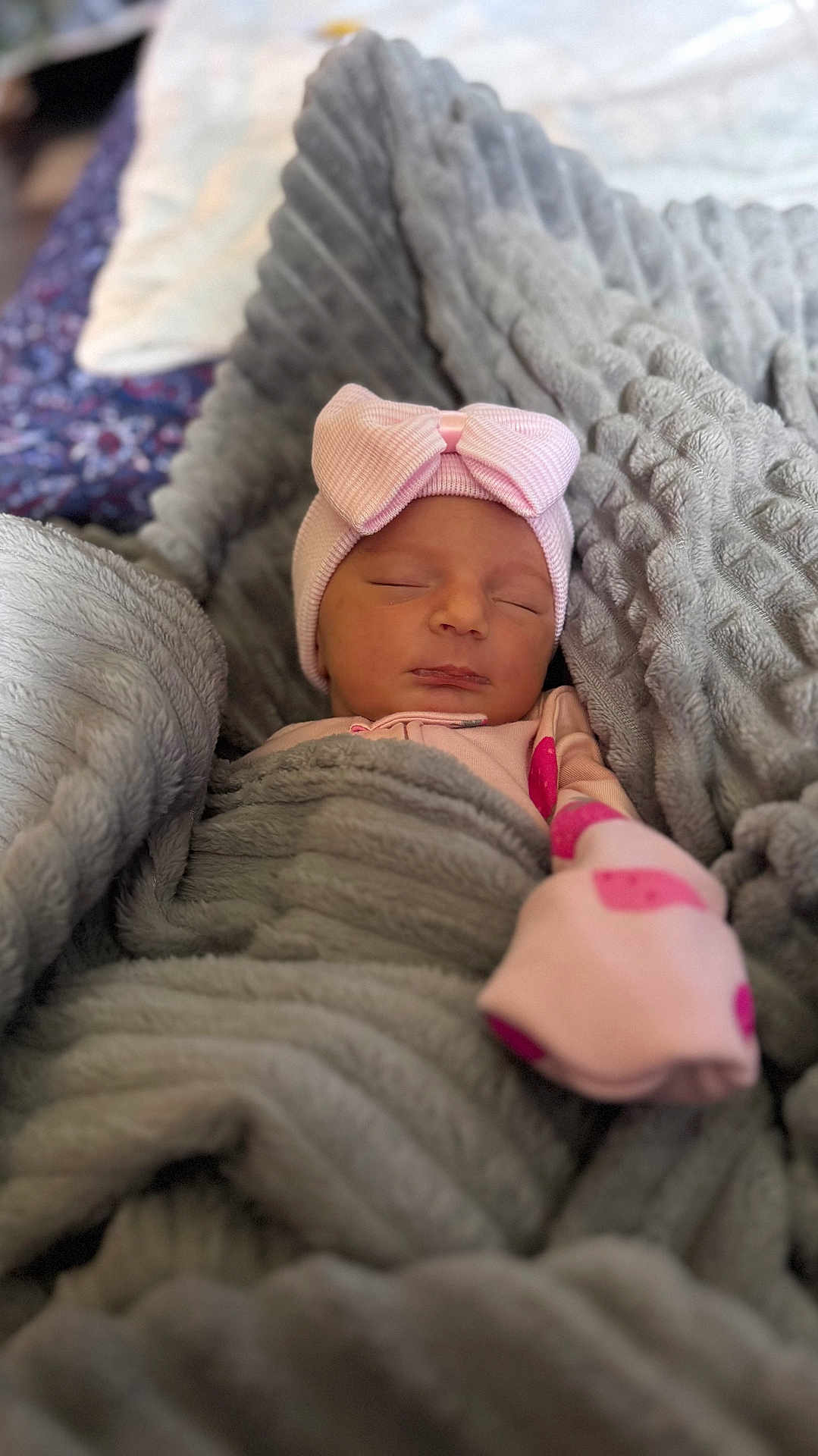 Kaylene is registered to the contest to win money with this photo: baby, newborn, sleeping, pink_hat, bow, blanket, swaddle, cozy, soft_texture, bokeh, portrait, indoor, bed, pajamas, nap, peaceful, cute, face, head, nursery