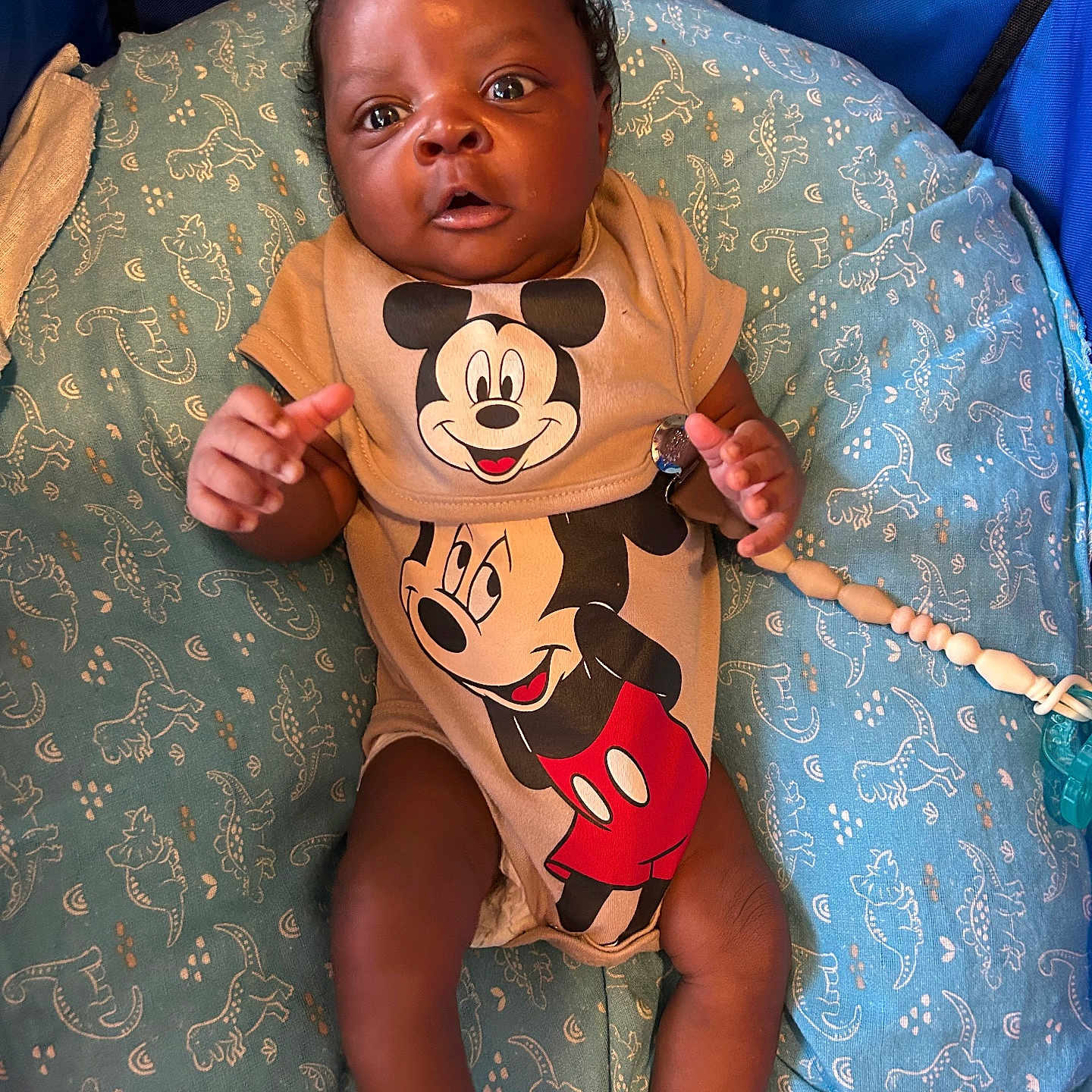 Kyzan joined the competition — help win amazing prizes! baby, blue_cushion, child, closeup, clothing, comfort, cute, expression, fabric, face, foot, hand, indoor, infant, lying_down, mickey_mouse, onesie, pattern, person, toy_clip