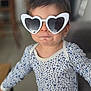 baby, child, clothing, cute, expression, face, fashion, funny, glasses, heart_shaped, home, indoor, person, playful, portrait, standing, star_pattern, sunglasses, toddler, young_child
