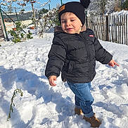 Livio participe au concours pour gagner de l'argent avec cette photo : black_jacket, blue_jeans, brown_boots, child, cold_weather, daylight, fence, footprints, happy, hat, nature, outdoor, playful, snow, snowy_ground, sunny, toddler, trees, winter_clothing, young_kid