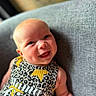 baby, smiling, infant, couch, clothing, leopard_print, text, mamas_girl, happy, portrait, face, cheeks, arm, indoor, child, cute, young, person, sitting, cozy