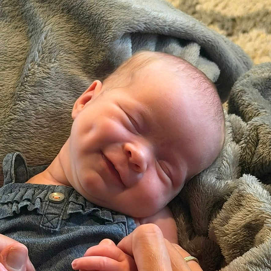Averi joined the competition — help win amazing prizes! baby, smiling, infant, blanket, hand, holding, face, sleeping, cozy, cute, newborn, person, portrait, skin, clothing, comfort, warmth, parent, love, rest