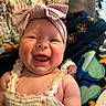 baby, child, smiling, headband, bow, dress, clothing, blanket, quilt, happy, cute, infant, portrait, person, indoors, cozy, face, cheerful, closeup, soft