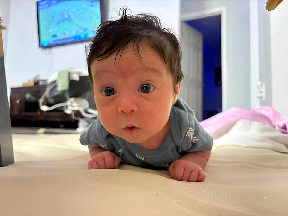 Brisa joined the competition — help win amazing prizes! baby, infant, tummy_time, curious, indoor, furniture, television, door, room, carpet, clothing, person, head, face, eyes, hands, skin, hair, expression, home