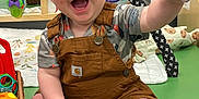 Leonard is registered to the contest to win money with this photo: baby, clothing, face, footwear, furniture, happy, head, indoors, jeans, pants, person, photography, plant, playarea, portrait, shoe, shorts, sitting, sneaker, toy
