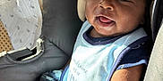 Timothy joined the competition — help win amazing prizes! baby, car_seat, bib, mittens, infant, child, happy, smiling, tongue_out, clothing, seatbelt, curly_hair, indoor, sunlight, person, cute, face, skin, expression, young