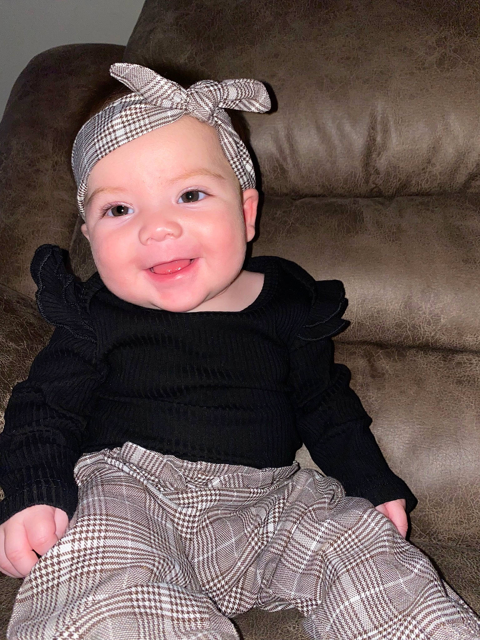 Ariella is registered to the contest to win money with this photo: baby, baby_toddler_clothing, black, child, collar, costume_hat, couch, face, flash_photography, happy, hat, head, headwear, joy, outerwear, pattern, person, sleeve, smile, t_shirt