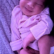 Kaylani joined the competition — help win amazing prizes! baby, smiling, sleeping, blanket, cozy, purple_light, infant, cute, soft_texture, clothing, wrapped, peaceful, portrait, newborn, child, resting, indoors, face, hand, leg