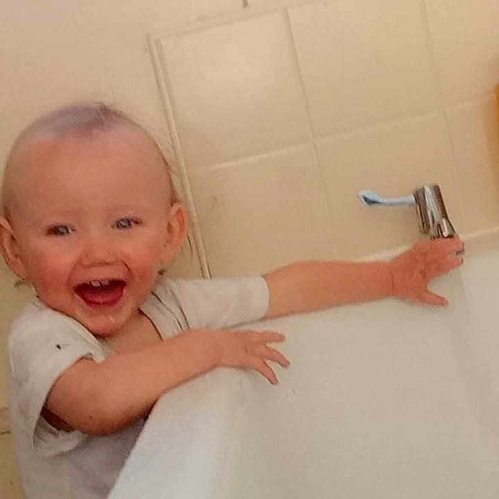 Jordan is registered to the contest to win money with this photo: baby, bathing, bathtub, bodypart, device, face, hammer, hand, happy, head, indoors, laughing, mouth, person, photography, portrait, sink, teeth, tool, tub