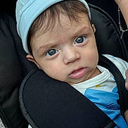 Luis Achim a rejoint le concours — aidez-le/la à gagner de superbes lots ! baby, beanie, blue_eyes, car_seat, child, close_up, clothing, curious, expression, face, human, indoor, infant, looking, patterned_shirt, portrait, seatbelt, sitting, white_shirt, young