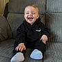 Myles joined the competition — help win amazing prizes! toddler, child, smiling, winking, black_hoodie, white_socks, couch, indoor, happy, sitting, portrait, baby, clothing, face, cute, funny_expression, person, home, cozy, young_child