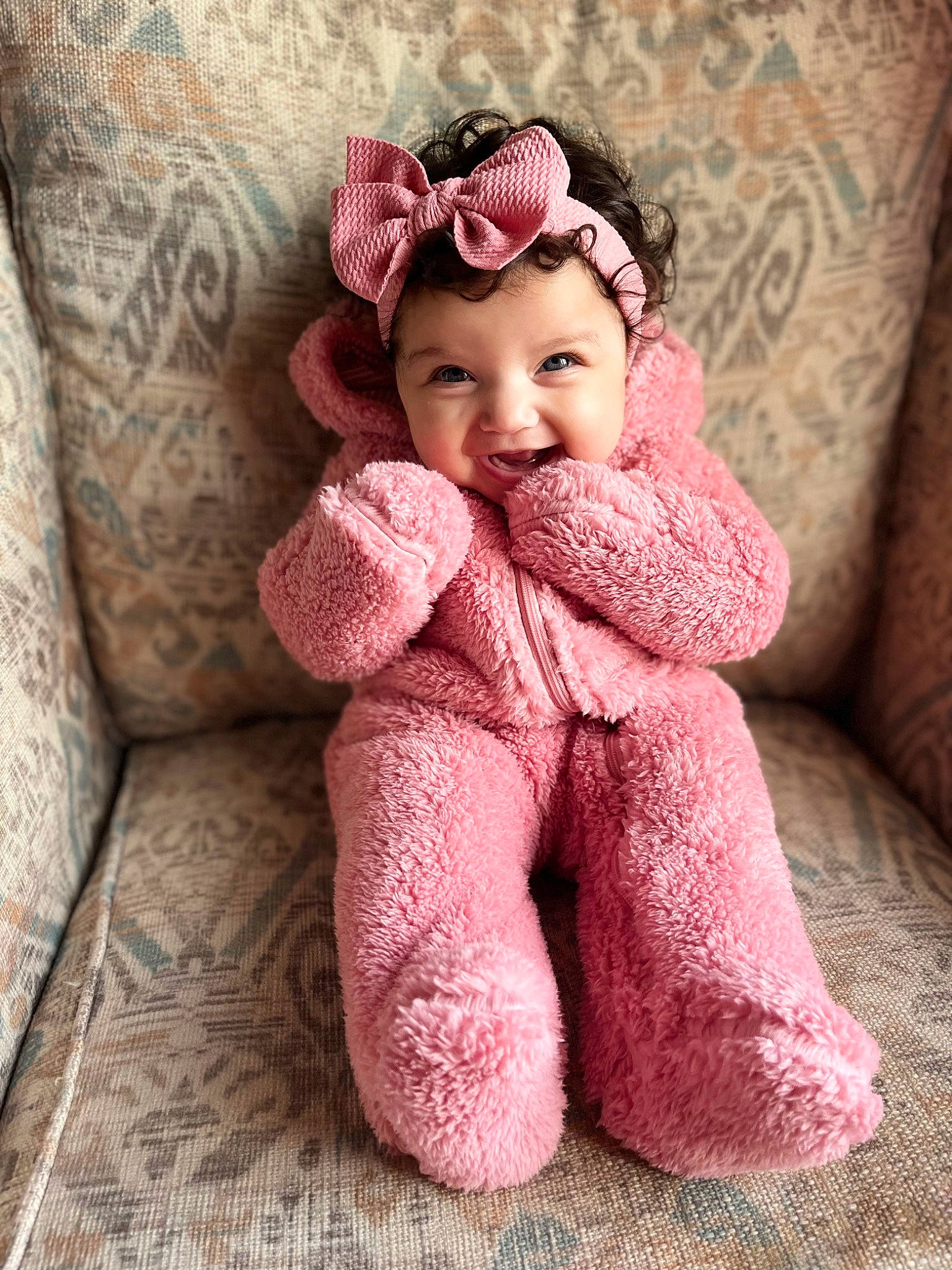 Iyla is registered to the contest to win money with this photo: baby, baby_toddler_clothing, cap, child, dress, fashion_accessory, flooring, fur, hair_accessory, happy, headpiece, headwear, linens, magenta, pattern, person, pink, sleeve, smile, textile
