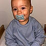 Livio a rejoint le concours — aidez-le/la à gagner de superbes lots ! toddler, child, pacifier, blue_sweater, sitting, bed, blanket, light_pants, indoors, hands, face, smile, calm, cozy, young_child, portrait, skin, hair, baby, casual_clothing