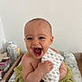 baby, child, smiling, laughing, towel, indoor, face, hand, skin, person, happy, pattern, paper, infant, cushion, baby_care, healthcare, sitting, young_child, background