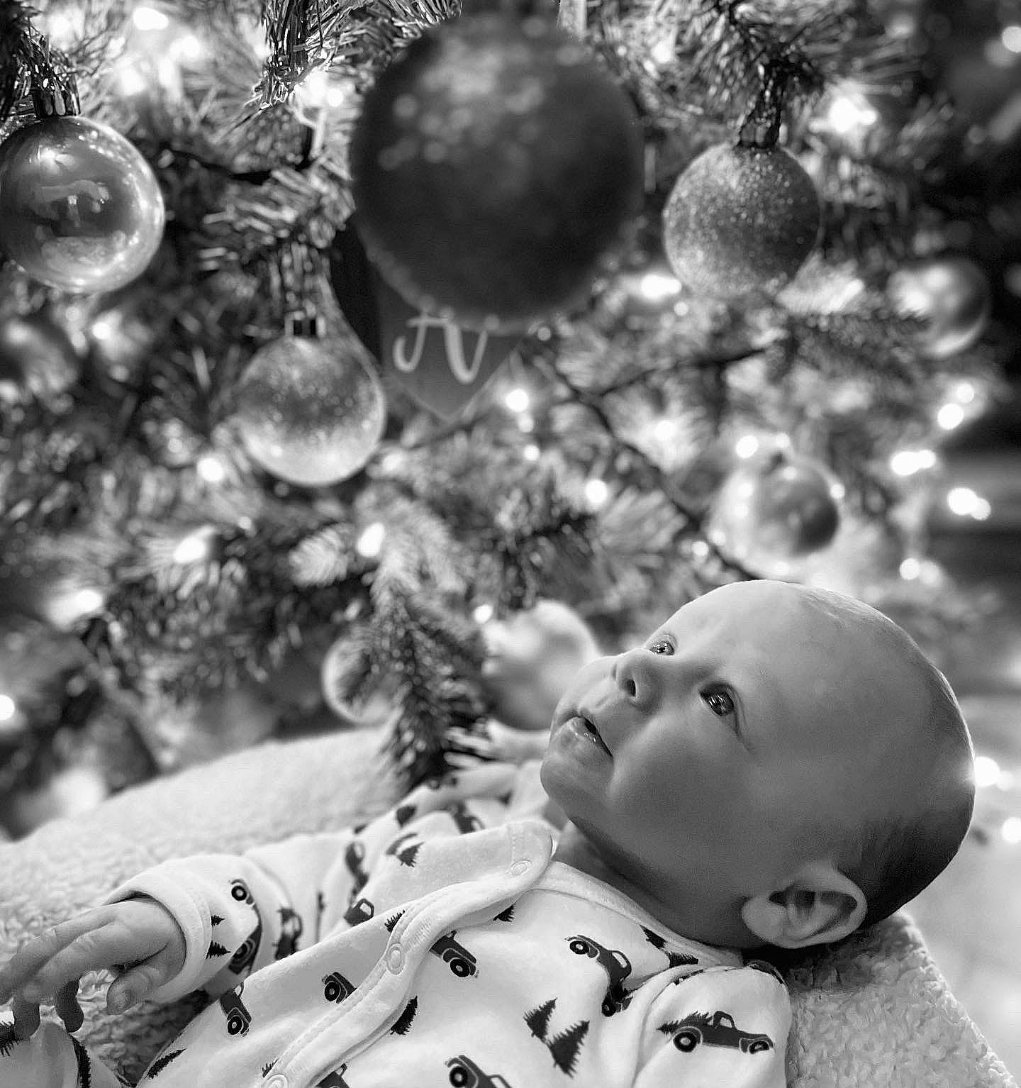 Bently is registered to the contest to win money with this photo: baby, black, black_and_white, branch, christmas_ornament, christmas_tree, grass, happy, leaf, monochrome, monochrome_photography, nature, ornament, pattern, people_in_nature, person, photograph, standing, toddler, white