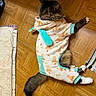 cat, feline, pet, fluffy, long_hair, black_and_white, lying_down, floor, wooden_floor, parquet, clothing, outfit, costume, carrot_pattern, turquoise, paws, tail, indoor, home, funny