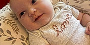 Bradley joined the competition — help win amazing prizes! baby, infant, smile, face, pillow, blanket, onesie, clothing, love, cute, child, skin, arm, hand, indoor, cozy, soft_light, comfort, portrait, closeup