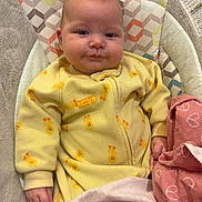 Bradley is registered to the contest to win money with this photo: baby, infant, yellow_onesie, duck_prints, blanket, pink_blanket, heart_pattern, baby_seat, cushion, indoor, child, person, cute, cozy, soft_fabric, sleepwear, hand, face, head, comfort