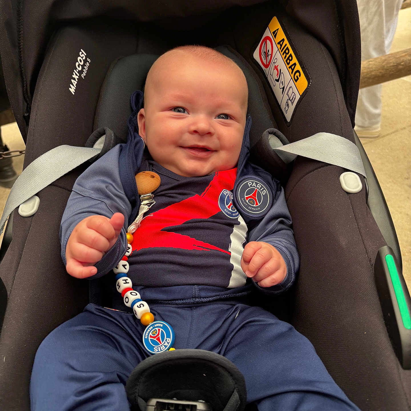 Sohan a rejoint le concours — aidez-le/la à gagner de superbes lots ! baby, car_seat, infant, smiling, blue_clothing, pacifier_clip, paris_saint_germain, happy, child, seatbelt, indoor, person, cute, casual, sporty, head, face, hands, footwear, comfort