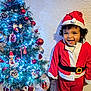 Malik participe au concours pour gagner de l'argent avec cette photo : candy_cane, celebration, child, christmas_lights, christmas_tree, curly_hair, decorations, festive, happy, holiday, indoor, joyful, person, pine_cones, red_baubles, santa_claus_costume, seasonal, smiling, toddler, winter