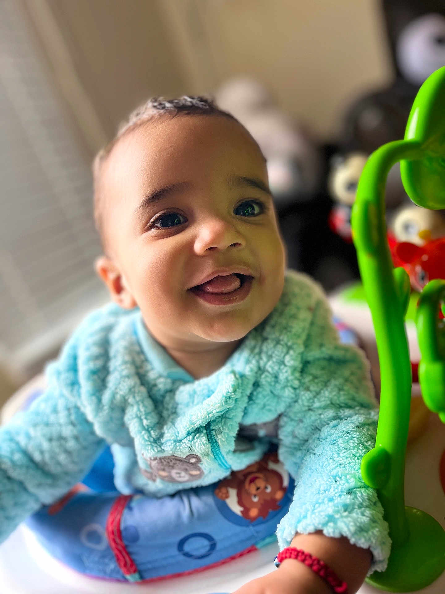 Milo is registered to the contest to win money with this photo: baby, child, smiling, blue_jacket, toy, indoor, cute, face, infant, happy, portrait, hand, fuzzy_clothing, playtime, closeup, young_child, expression, bright_eyes, crawling, colorful