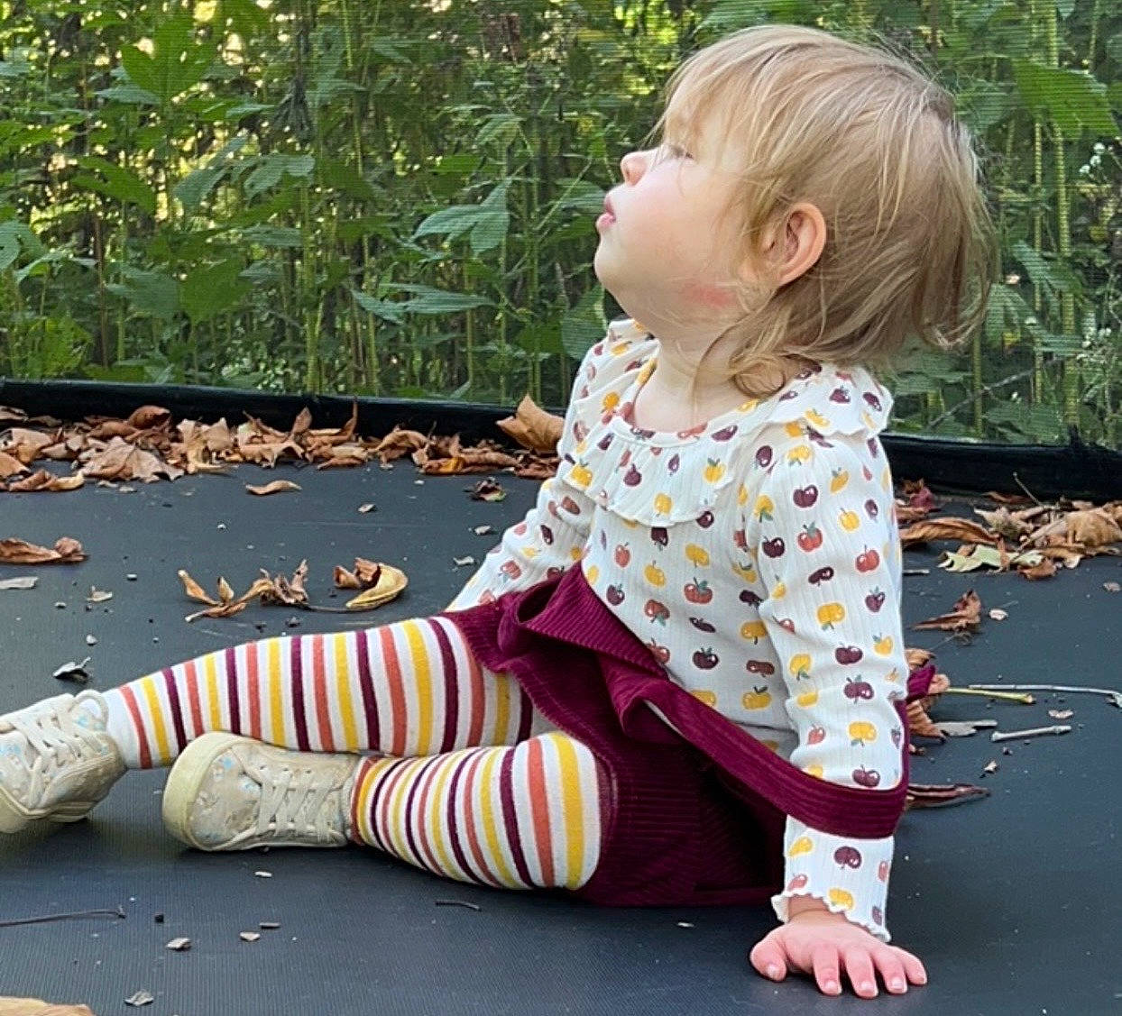 Alice joined the competition — help win amazing prizes! baby_toddler_clothing, child, dress, flooring, foot, grass, hairstyle, human_leg, leg, leisure, mammal, pattern, people_in_nature, person, plaid, plant, road_surface, sitting, sleeve, toddler