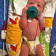 Grayson is registered to the contest to win money with this photo: newborn, baby, pacifier, medical, iv, blanket, diaper, monitoring, hospital, infant, cute, lying_down, patchwork, wires, tubes, skin, hospital_care, patient, small, healthcare