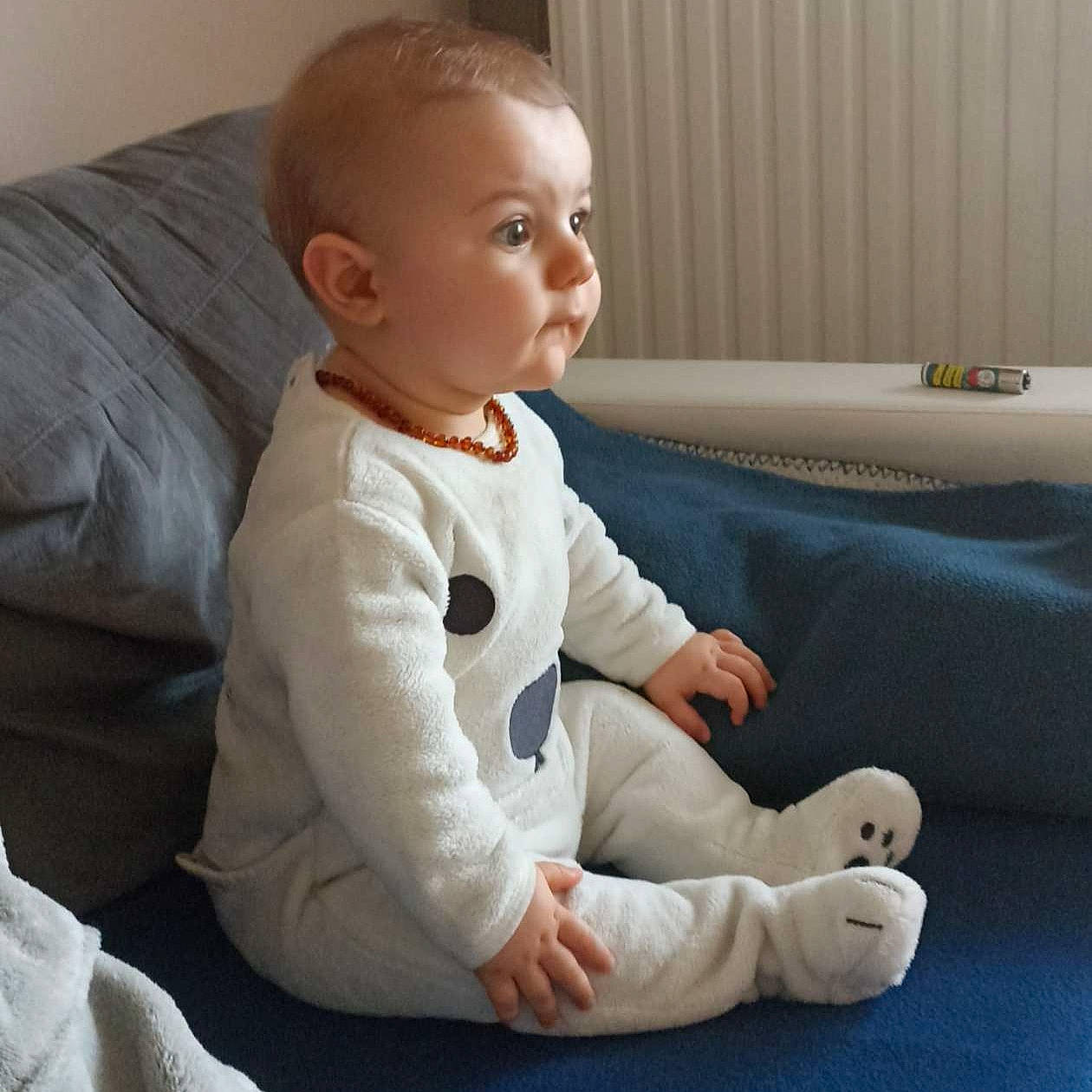 Malonn participe au concours pour gagner de l'argent avec cette photo : arm, baby, baby_toddler_clothing, child, comfort, couch, elbow, finger, floor, flooring, head, human_leg, knee, linens, person, room, sitting, sleeve, studio_couch, thumb
