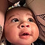 Marley is registered to the contest to win money with this photo: baby, close_up, face, infant, curious, expression, skin, mouth, eyes, eyelashes, clothing, fabric, tattoo, arm, soft_lighting, portrait, indoor, cute, child, person