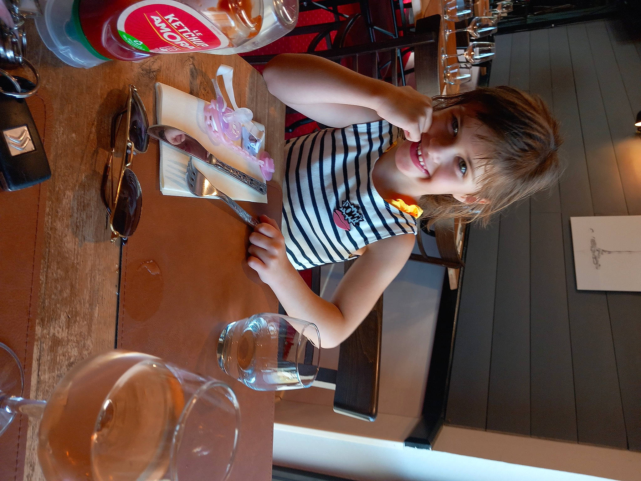 Maëlys participe au concours pour gagner de l'argent avec cette photo : chair, child, coca_cola, cooking, drink, drinkware, eyewear, fun, glass, happy, joy, leisure, logo, person, plate, room, smile, t_shirt, table, tableware