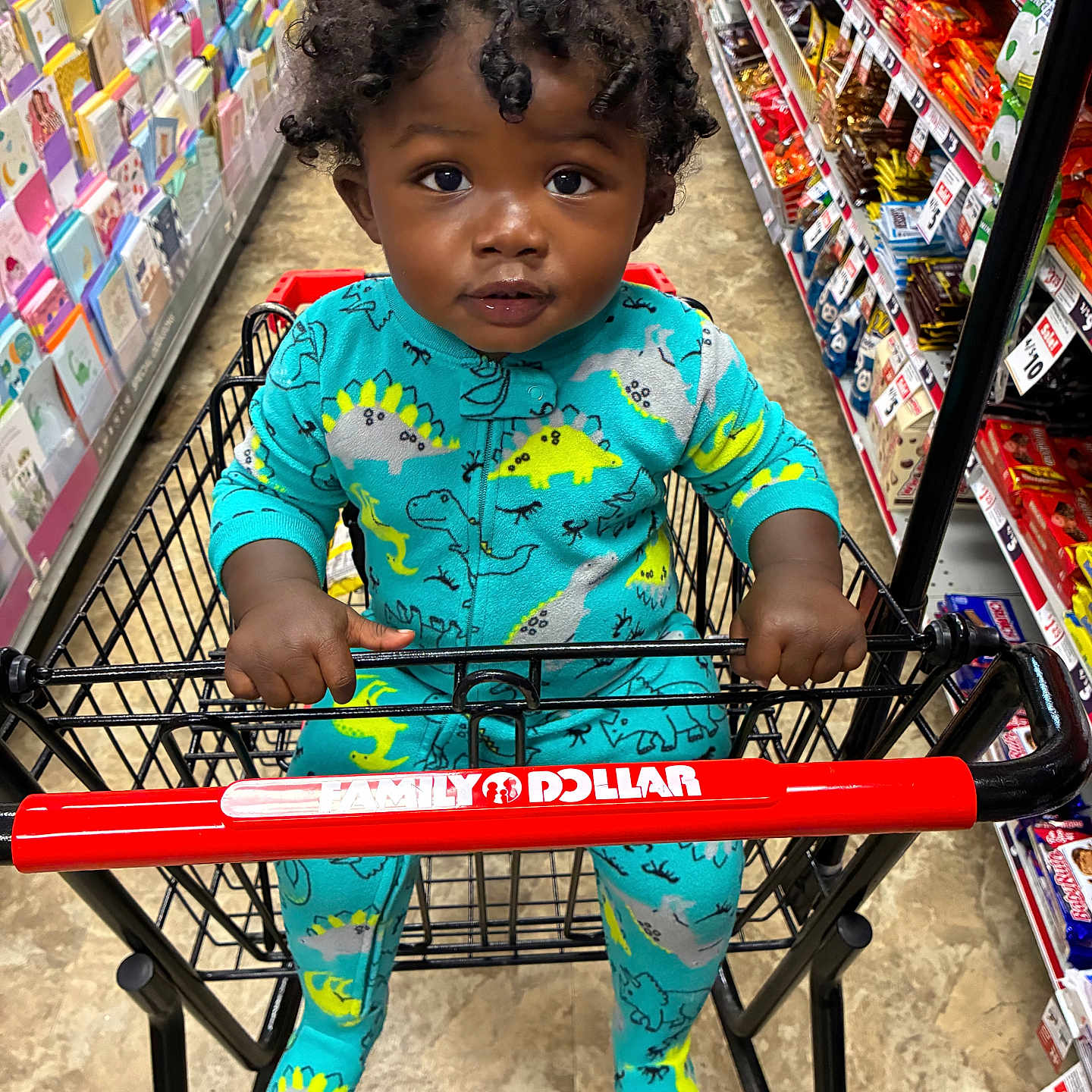Hassan Taylor joined the competition — help win amazing prizes! baby, candy, cart_handle, child, colorful, curly_hair, dinosaur_pattern, greeting_cards, gripping, grocery_store, indoor, portrait, retail_aisle, shopping, shopping_cart, sitting, snacks, store, toddler, turquoise_clothing
