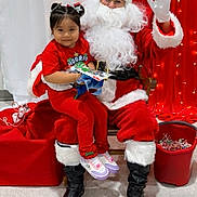 Kayla Charlotte is registered to the contest to win money with this photo: child, santa_claus, christmas, holiday, red_clothing, gift, smile, boots, lights, curtain, indoor, festive, person, celebration, happy, sitting, decorations, toy, bag, glasses