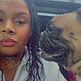 woman, dog, pug, braided_hair, tattoo, white_jacket, car_interior, sunroof, closeup, portrait, pet, animal, companion, seated, leather_seat, curious, indoors, friendship, expression, side_profile