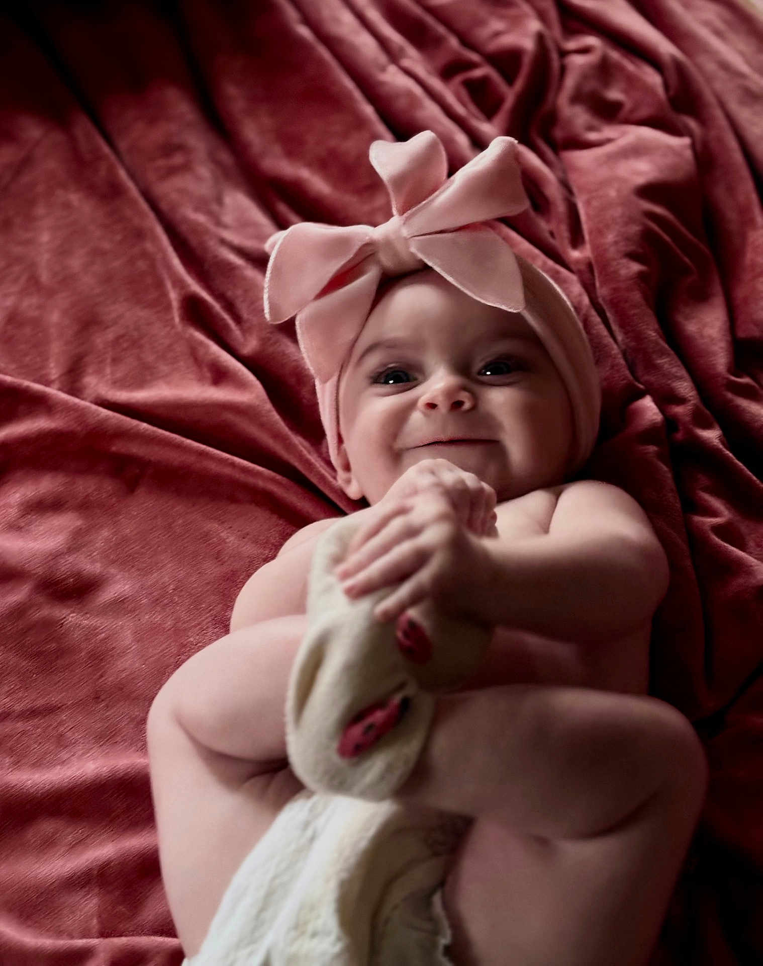 Kodi joined the competition — help win amazing prizes! baby, infant, smile, headband, bow, blanket, soft_texture, skin, cute, happy, hand, foot, lying_down, close_up, indoors, child, portrait, playful, toddler, expression