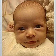 Nour a rejoint le concours — aidez-le/la à gagner de superbes lots ! baby, infant, face, eyes, smile, newborn, blanket, soft_texture, cozy, cute, portrait, child, warm, closeup, clothing, lying_down, indoor, skin, head, young