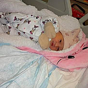 Nour a rejoint le concours — aidez-le/la à gagner de superbes lots ! baby, blanket, child, clothing, cozy, cute, face, hat, hospital_bed, indoors, infant, mittens, newborn, onesie, person, pink, resting, sleeping, soft, white