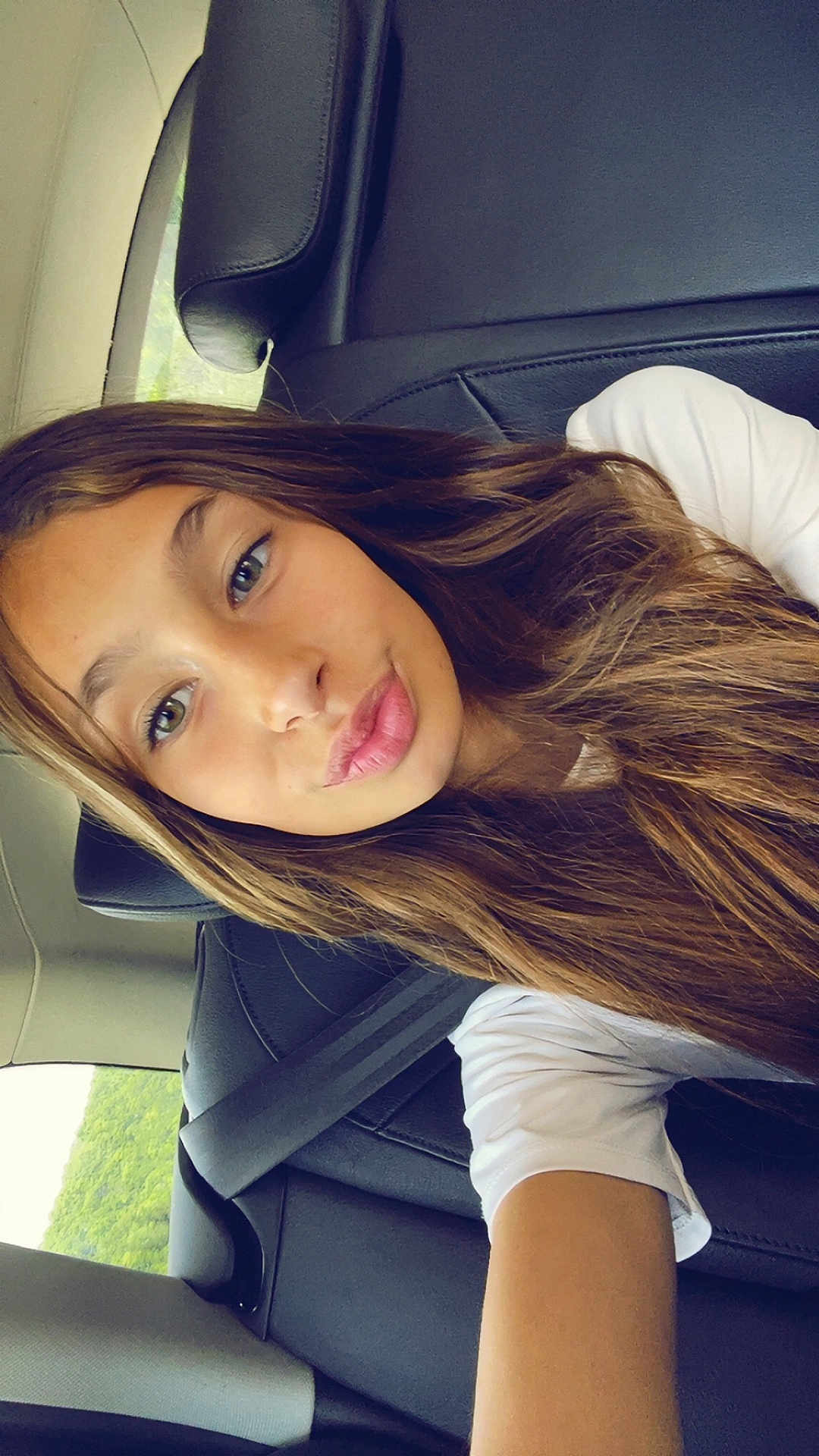 Leonor participe au concours pour gagner de l'argent avec cette photo : child, girl, selfie, car, seatbelt, long_hair, white_shirt, pout, portrait, face, window, seat, interior, casual, young, person, daylight, smile, skin, expression