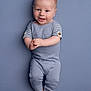 Jonah is registered to the contest to win money with this photo: baby, infant, smiling, blue_outfit, hands_clasped, barefoot, lying_down, portrait, studio, cute, child, happy, one_person, young_child, indoor, knitted_clothing, face, head, feet, background