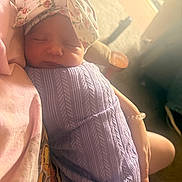 Hannah joined the competition — help win amazing prizes! baby, newborn, sleeping, blanket, headband, purple, knitwear, person, arms, indoor, soft_light, cozy, peaceful, closeup, portrait, infant, child, skin, hand, resting