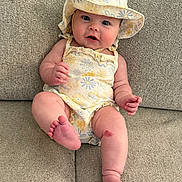 Lyla joined the competition — help win amazing prizes! baby, infant, hat, romper, couch, fabric, skin, face, eyes, legs, feet, hand, sitting, child, cute, expression, indoors, texture, scrape, clothing