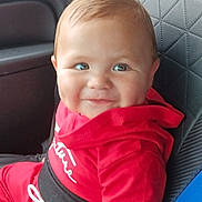 Joshua is registered to the contest to win money with this photo: baby, child, car_seat, red_clothing, smile, dimples, indoor, seatbelt, cute, person, young_child, portrait, sitting, car_interior, clothing, hoodie, hand, face, happy, infant