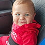 baby, child, car_seat, red_clothing, smile, dimples, indoor, seatbelt, cute, person, young_child, portrait, sitting, car_interior, clothing, hoodie, hand, face, happy, infant
