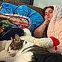 Swisher is registered to the contest to win money with this photo: person, cat, sleeping, couch, blanket, stuffed_animal, indoor, relaxation, tattoo, pillow, colorful, cozy, resting, feline, nap, home, comfort, animal, fur, soft